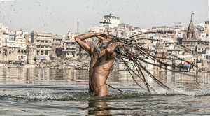 Agori pilgrim bathing in the Ganges river, India